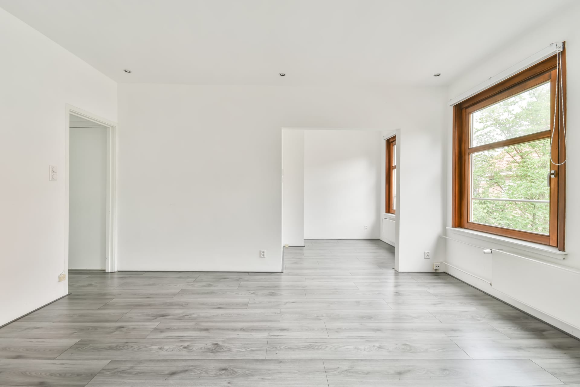 Empty, freshly cleaned room with gleaming floors and natural light